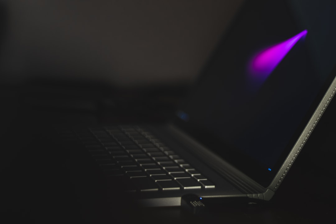 close-up of a laptop with a glowing display against a dark background