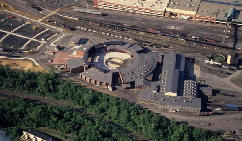 Aerial view of an industrial complex with circular structures and surrounding landscape.