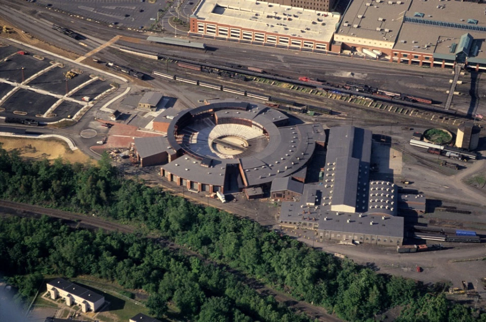 Aerial view of an industrial complex with circular structures and surrounding landscape.